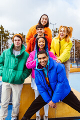 Multiracial group of young friends meeting outdoors in winter - Multiethnic students with colorful...