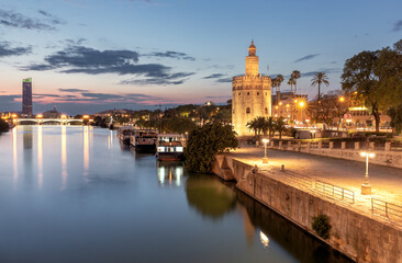The golden tower of Torre del Oro in night illumination at sunset. - obrazy, fototapety, plakaty