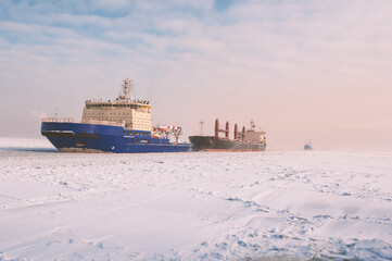 Winter shipping. Big cargo ships in ice sea fairway