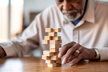 African American Senior man with dementia playing with wooden blocks in geriatric clinic or nursing home - obrazy, fototapety, plakaty