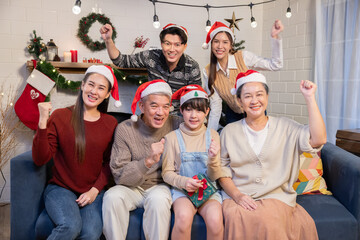 Happy Asian family sitting on a couch at family christmas party