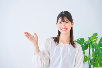 案内のポーズをする若い女性
