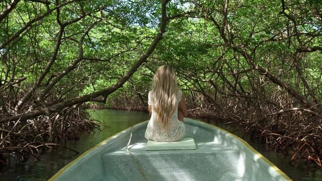 Girl on boat entering in a lake surrounded by trees