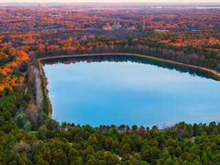 Fall colors surrounding a lake from an aerial view