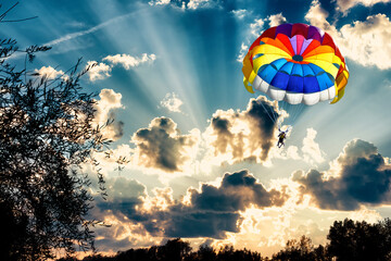 Paragliding with a parachute on the background of sunset.