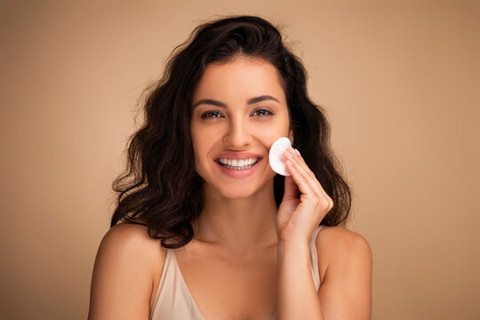 Woman removes makeup from the face with a cotton pad