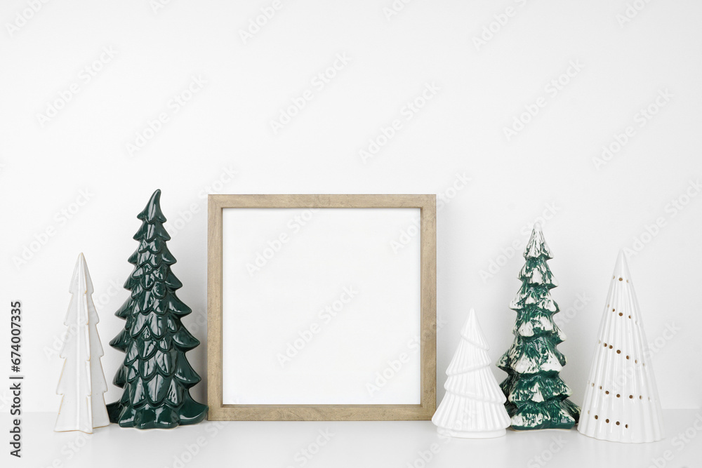 Aufkleber christmas mock up with wooden frame and tree decor. square frame on a white shelf against a white wa