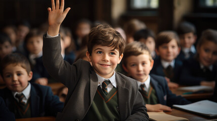 student at a desk in a school class raises his hand, child, smart kid, children, study, learning, classroom, knowledge, lesson, pupil, schoolboy, boy, uniform, european, tie, smile, portrait, face