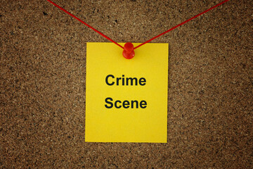 A yellow paper note with the words Crime Scene on it pinned to a detective board with red threads....
