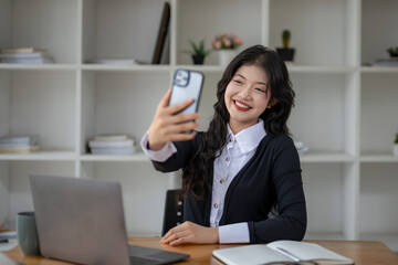 Asian woman making selfie on a smartphone camera or recording video vlog on a mobile phone.