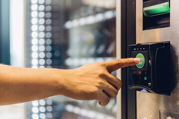 Hand man use of soft drink vending system. Man use drink coin machine at smart office or Public park. People use  Vending Machine, is robotic for the high-quality drink - obrazy, fototapety, plakaty