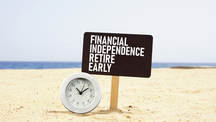 Financial independence retire early FIRE is shown using the text and photo of the clock on the beach