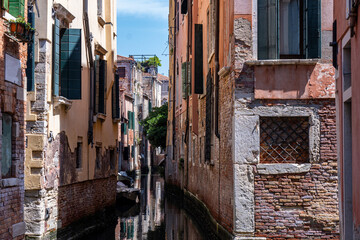 Scenic canal with bridge and old buildings with potted plants in Venice, Italy
