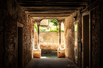 Old, empty arched hall or passage made of bricks with wooden beams in Venice, Italy
