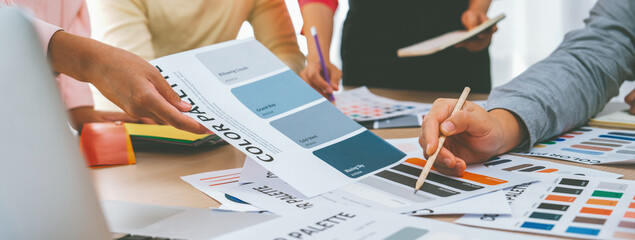 A cropped image of professional interior designer discuss the color material with her colleagues by...