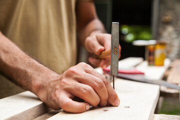 Carpenter with hammer making wooden fence