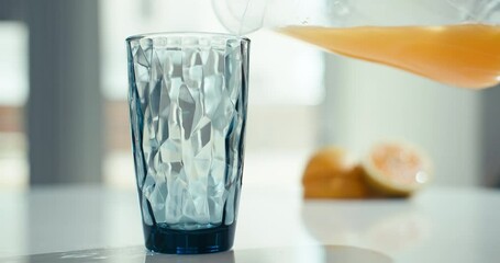 Background slow-motion video of pouring a carafe of orange juice into a glass. Fresh organic juice for breakfast at home in the kitchen. High quality 4k footage - Powered by Adobe