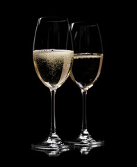 Two champagne glasses on a black