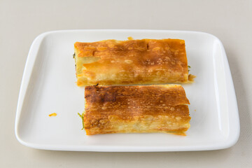 Turkish style meat stuffed filo dough borek served kol boregi. Cheese and minced pie are sliced on a marble background. Turkish name: Kol Boregi, ispanakli, kiymali, Su Boregi