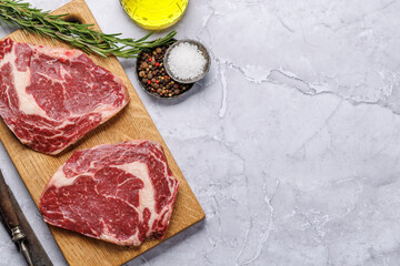 Raw ribeye steaks with savory spices