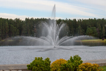 Naklejka premium a beautiful fountain in an outdoor park on a cloudy day.