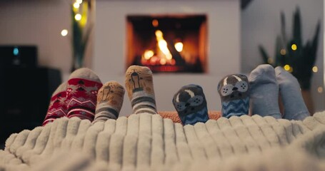 Christmas, socks and family by the fireplace on a sofa in the living room in their home together. Love, children and parents feet closeup while bonding in the December festive season for celebration