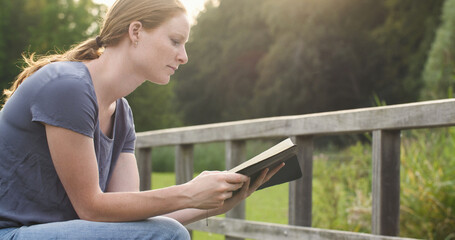 Woman reading the bible in a park. Christian faith and bible study - 674074958
