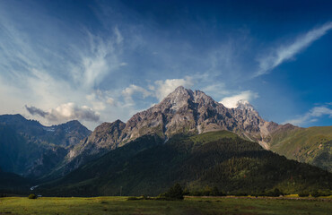 Panorama with high resolution. View of mount Ushba, from Mazeri, Georgia. Summer day, blue sky, sunset time. Mountains, nature landscape. Travel and hiking concept