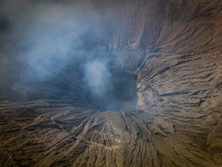 Aerial landscape view of the Bromo volcano crater with smoke coming. An active volcano in Tengger...