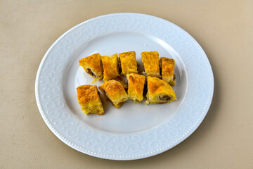 Turkish style meat stuffed filo dough borek served kol boregi. Cheese and minced pie are sliced on a marble background. Turkish name: Kol Boregi, ispanakli, kiymali, Su Boregi