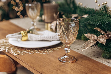 Cozy flat apartment photo studio room green Christmas Tree gifts presents garlands, candles decorated dinner table settings toys balls interior New Year lights glowing bokeh