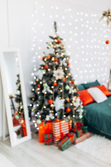 Vertical blur bokeh flat apartment room green Christmas Tree gifts presents garlands, candles decorated interior New Year beautiful living room in the evening, lights glowing