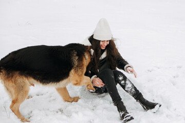 Young woman walk the dog German Shepherd in winter field forest, running playing with snow, training the animal in harsh conditions, wind blowing. Christmas Time, New Year