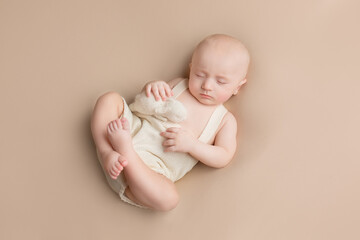 a small child lies on a light background. newborn boy. baby's first photo shoot