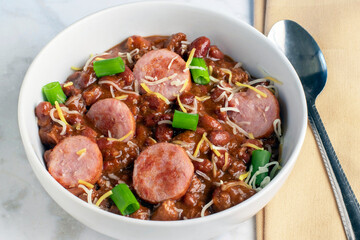 chili top with kielbasa , scallions and  cheese