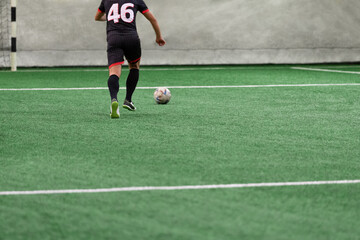 Ball and arena soccer player on the field during the game.