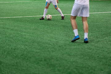 Obraz premium Five-a-side soccer players playing game in indoor stadium on artificial turf.