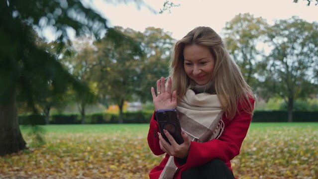 The woman communicates through her phone via video link