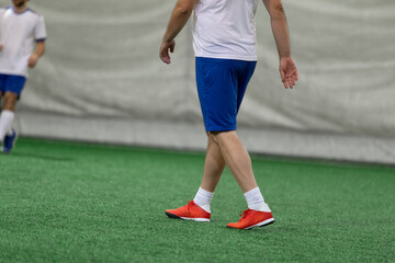 Obraz premium Futsal five-a-side players on artificial grass field indoor.