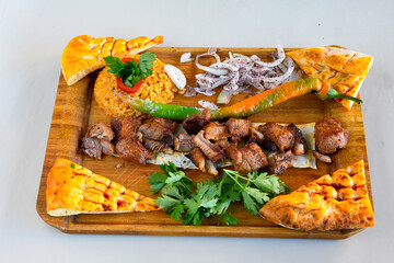 Beef steak grill with rice pilaf, fried potatoes, grilled pepper and tomatoes.Mix Platter with Beef rips, Cutlets, Potatoes and Sauces.