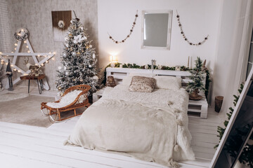 Cozy flat apartment photo studio room sled sleigh green Christmas Tree gifts presents garlands, candles decorated toys balls interior New Year lights glowing bokeh 
