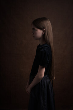 Classic dark renaissance portrait of brunette girl seen en profile