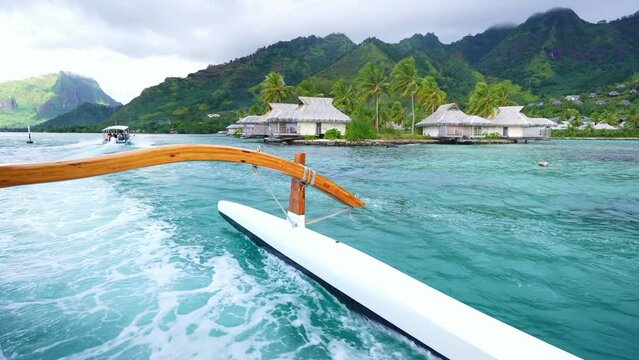 Traditional Polynesian canoe boat in Moorea island, blue lagoon in Tahiti, French Polynesia. Popular tourism destination tropical island. Island culture and traditions. 
