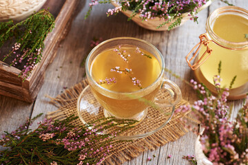 Heather or calluna vulgaris flowers with a cup of herbal tea or infusion