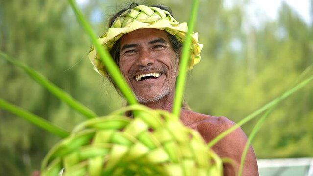 Traditional man in Tahiti making a hat. Island and Polynesian culture. Bora Bora, French Polynesia. Luxury travel vacation, paradise getaway, romantic honeymoon exotic destination. 