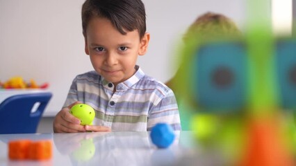Elementary age kids playing with electronic toy car with joystick in technological educational course. Children development, education, fine motor skills