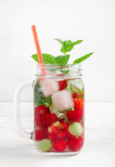 Fresh cool drink of ripe juicy cherry, strawberry, currant and gooseberry berries