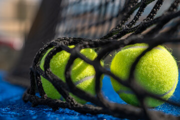 selective focus of two balls beyond the net of a paddle tennis court