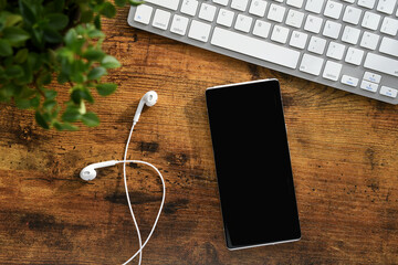 A phone with earbuds for listening to audiobook, music or podcast - blank screen mock up