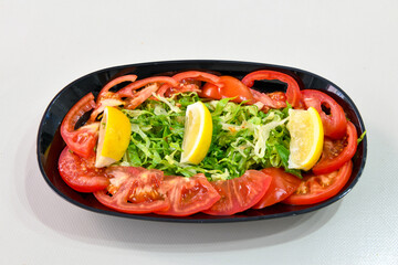 Green salad with arugula, lamb and tomatoes. Healthy vegan dish. Top view at table. Turkish Coban (choban) salata or Shepherds salad, Akdeniz salad in white bowl.